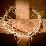 Crown of thorns hanging on a wooden cross at Easter